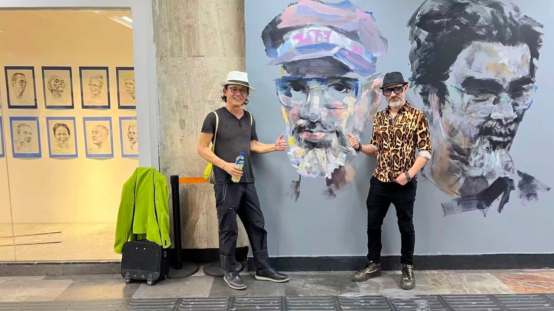 Artists in front of the Mexico City Metro mural